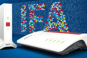 Zu sehen sind eine FRITZ!Box und ein FRITZ!Repeater vor dem IFA-Schriftzug im Hintergrund.