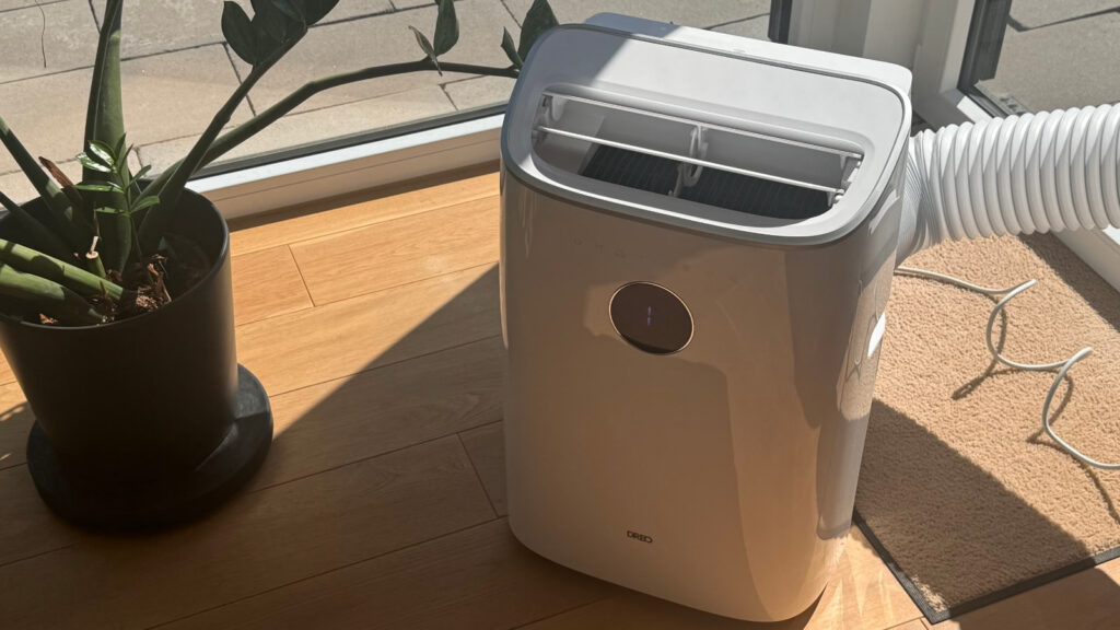 Dreo Mobile Klimaanlage 318S im Test, aufgestellt in einem Wohnraum mit angeschlossenem Abluftschlauch zum Fenster